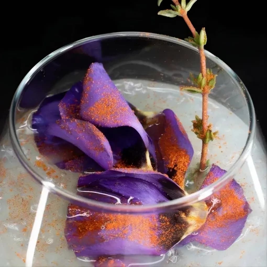 Напиток с фиолетовыми элементами в стеклянной посуде